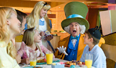 Mad Hatter and Alice entertain a family during breakfast.