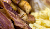 Close-up shot of glistening bacon and fluffy eggs.