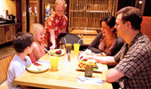 A family, seated inside the restaurant, is served fresh fare.