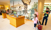 Guests look at character maquettes and statues in glass cases on display in the lobby.