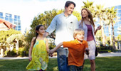 A family of 4 walks through the Disneyland Hotel courtyard.