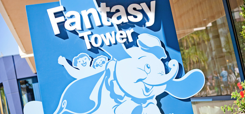 The Fantasy Tower sign with an illustration of a child riding The Dumbo the Flying Elephant attraction