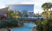 A wide shot of the Disneyland Hotel, one of the 3 pools and the footbridge.