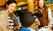 Mom smiles at her boy wearing Mickey ears.