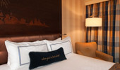 Disney touches near the bed include a carved headboard and a beautifully stitched throw pillow.