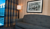 A comfortable sofa sits beneath a framed collage of images from Disneyland history.