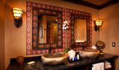 Stone-work sinks and mirrors in African-themed art frames.