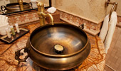 Copper-designed sink set on a marble counter.
