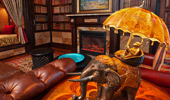 An artistic and whimsical lamp: a monkey riding an elephant, holding an umbrella that doubles as the lamp shade.