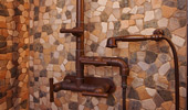Shower fixtures surrounded by stone work.