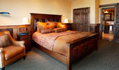 King bed in a room designed with wood and leather.