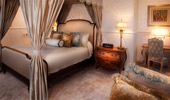 Canopied king bed with artwork of Disney couples, like Belle and the Beast.