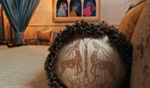 Detail on a pillow of 2 delicate, horned and 4-hoofed fauna.
