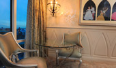 Fanciful chairs near a framed photo collage of Disney couples.