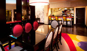 The view from the dining area to the bar boasts a burst of primary shapes and colors.