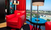 A couple of red reading chairs, a table and lamps are artfully arranged.