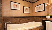 The sophisticated bathtub area is decorated in beige, brown and beautiful marble.