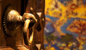 An Old-World style knocker on a weathered wood door. 