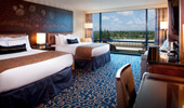 2 queen-size beds near a large window.