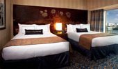 2 queen-size beds near a large window.