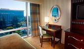 Comforts of contemporary design: a dark wood writing desk, Mickey-themed lamp and a silver bordered mirror