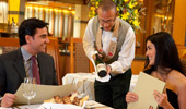 A sommelier recommends a wine to a couple dining at Napa Rose.
