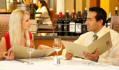 A couple, enjoying an evening out, discuss the delicious dinner selections on the menu.