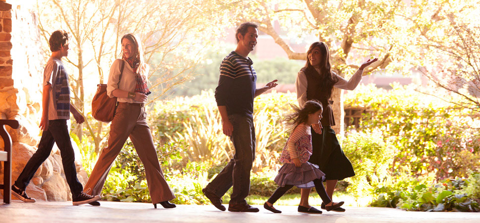 A family of 4 follows a tour guide through the grounds of Disney's Grand Californian Hotel & Spa.