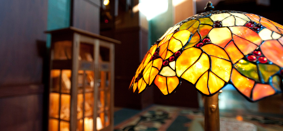 Close up on a hand-crafted glass lamp shade inspired by leaves glowing in golden California sunlight.