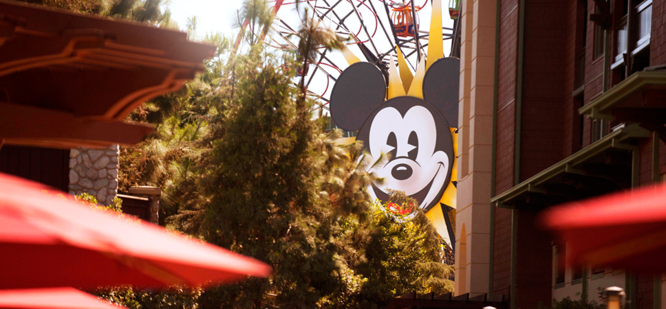 Through the trees, see the iconic face of Mickey Mouse on Mickey's Fun Wheel, a Disney California Adventure Park attraction.