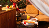 Full trays of food and drinks a inside a cabana