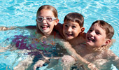 3 kids play in the pool.