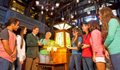 Guests gather around beautiful lamps to learn about the design style.