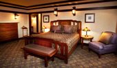 A king-size bed is surrounded by simple, but elegant, furnishings.