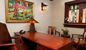 A impressive workstation with luxurious leather chair, impressive wood desk and Arts and Crafts-inspired artwork.