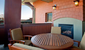 Private balcony with table, chairs and outdoor fireplace.