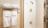 Shot of fluffy towels and an elegantly white-tiled shower