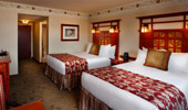 Wide shot of room with rose theme throughout: on the carpet, bedspread and crowning the walls