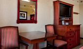 Sitting table with 2 chairs, a sideboard with coffee maker and mirror reflects the beauty in the room