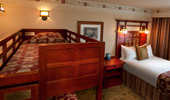 The view of the top bunk, also decorated with warm reds and wood
