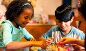 Close up on 2 young Guests playing a board game.