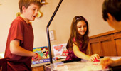 Close up on kids playing air hockey.