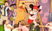 Pluto, Mickey and a Surfer Dude lead kids in a pantomime dance that mimics jumping in the water.