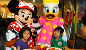 Minnie and Daisy pose for a photo with a boy and girl.