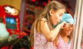 2 girls point to something within a glass enclosure.