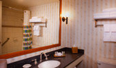The shower curtain with surfboard design is reflected in the bathroom mirror.
